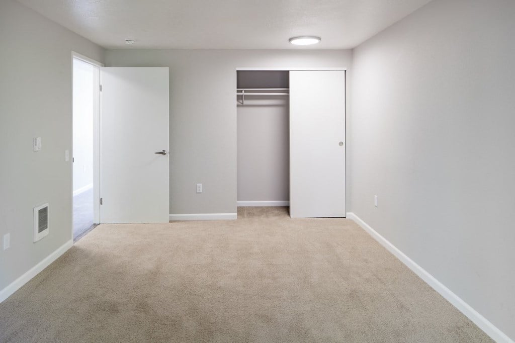 A room with a carpeted floor and a white door.