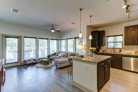 A kitchen with a large island and a dining area with a table and chairs.