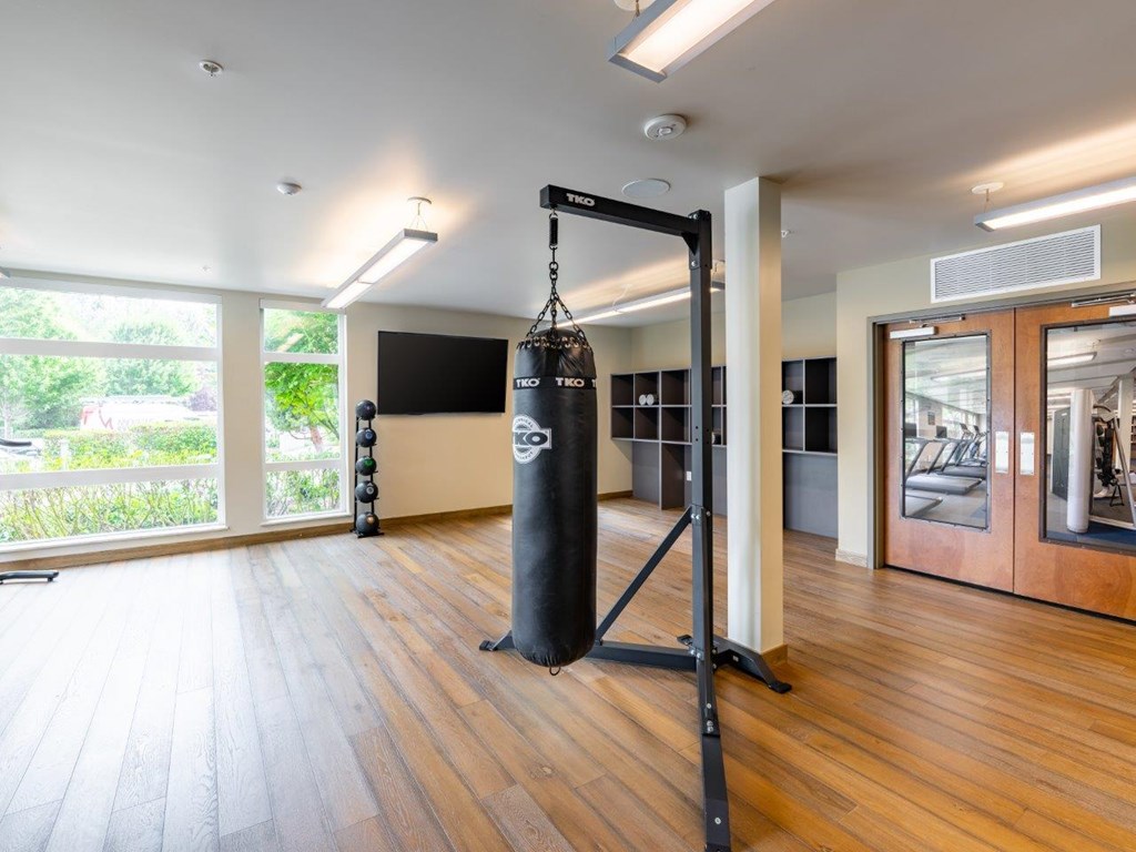A room with a punching bag and wooden floors.