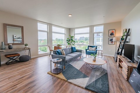 A living room with a grey sofa and a wooden floor.