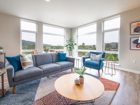 A living room with a grey couch, blue chair, and a wooden coffee table.