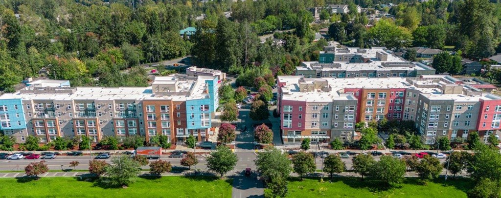 A large building complex with a parking lot in front.