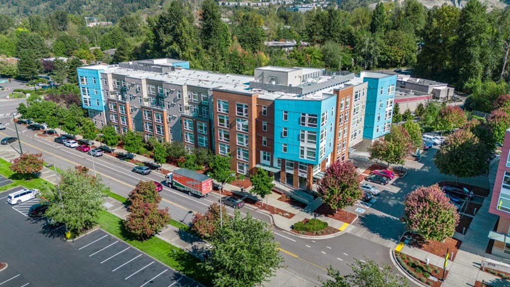 A parking lot in front of a multi-story building.