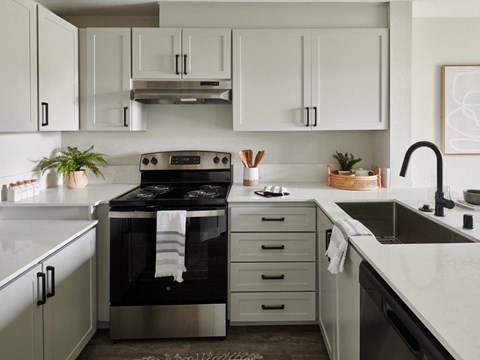 a black and white kitchen with stainless steel appliances and white cabinets