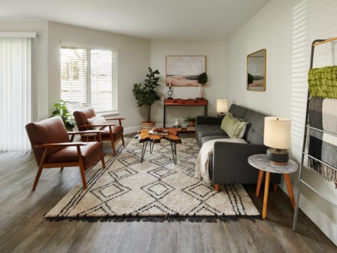 a living room with a couch and chairs and a rug