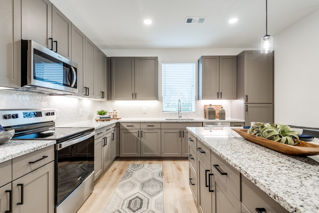 Aura 3Twenty Apartments open kitchen with granite counter tops and stainless steel appliances