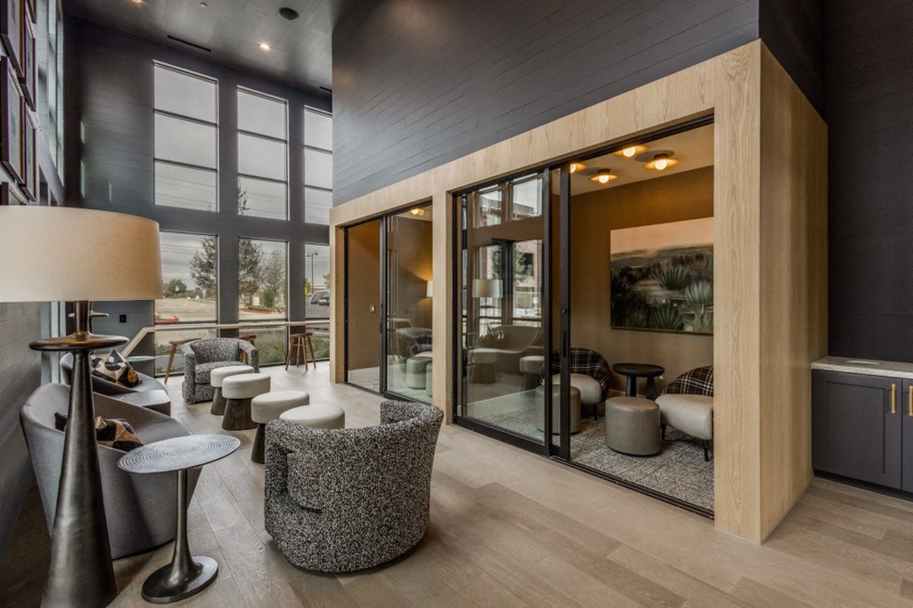 the lobby of a hotel with tables and chairs and large windows