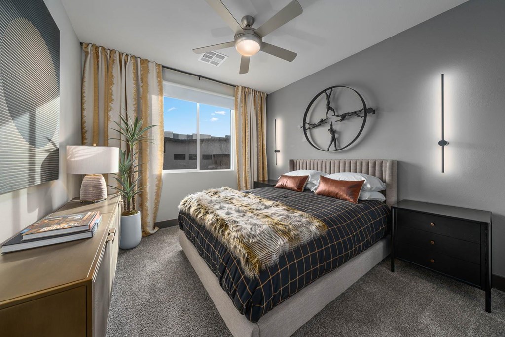 A bedroom with a bed, nightstand, and window with curtains.