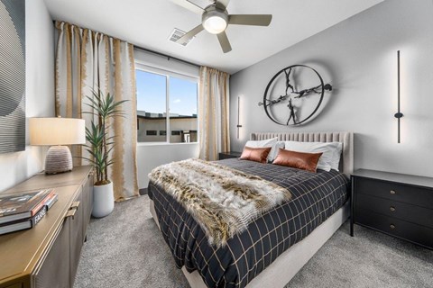 A bedroom with a large bed and a ceiling fan.