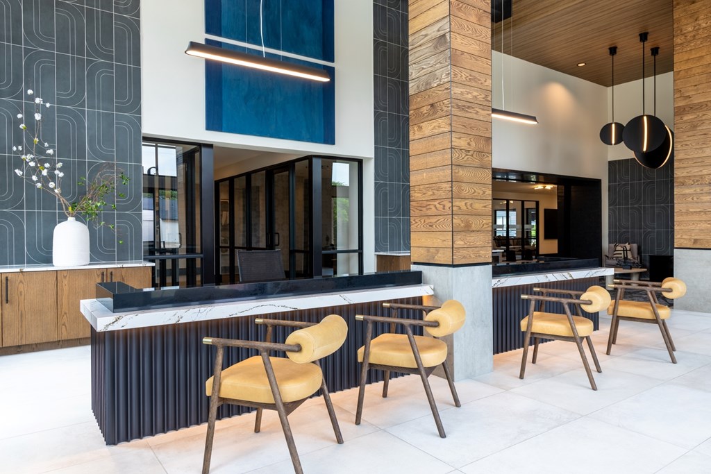 A modern kitchen with a long island and chairs.
