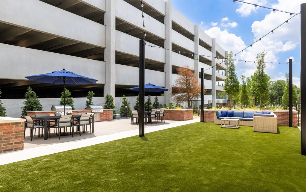 A parking garage with a grassy area in front of it.