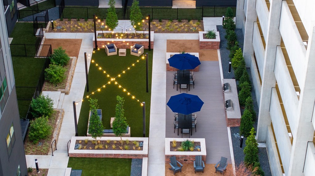 A rooftop garden with a table and chairs.