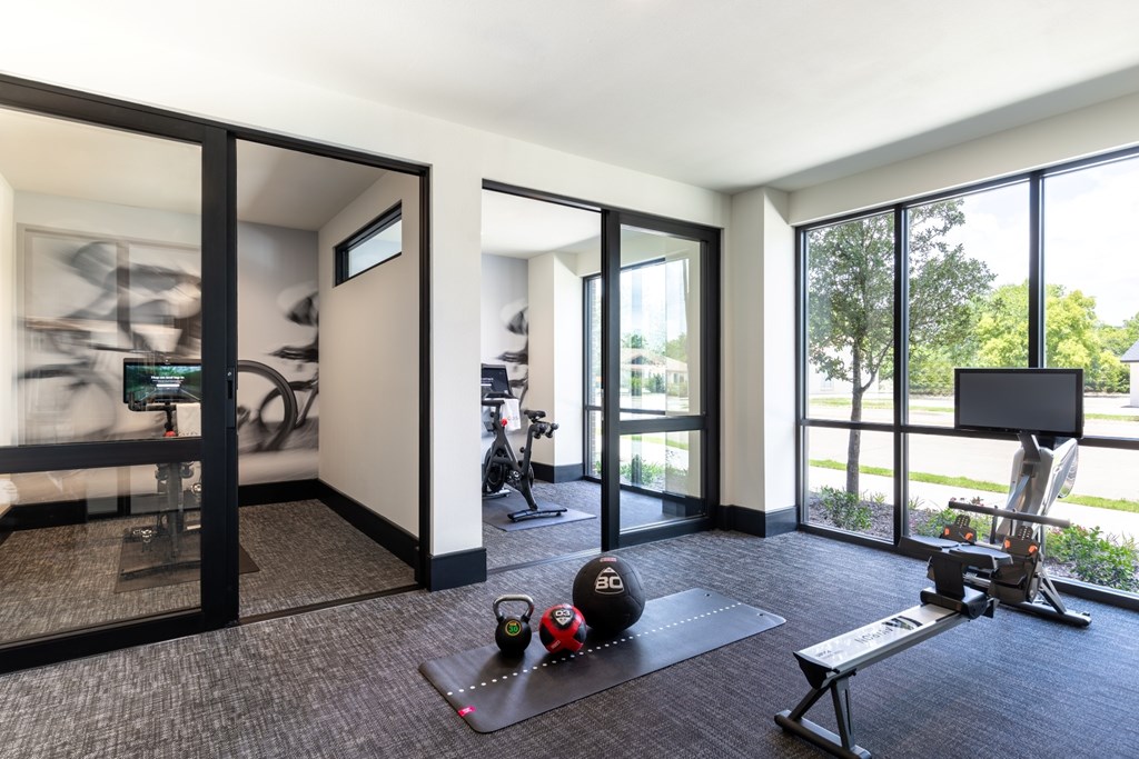 A room with a treadmill, exercise ball, and a bench.
