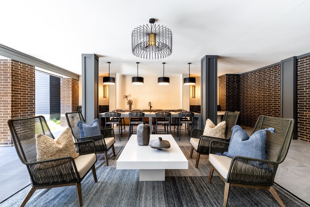 A modern living room with a white coffee table and black chairs.