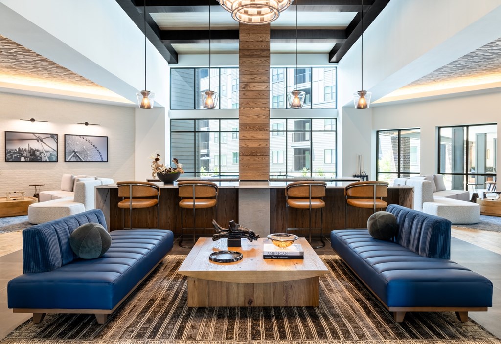 A modern living room with blue couches and a wooden coffee table.