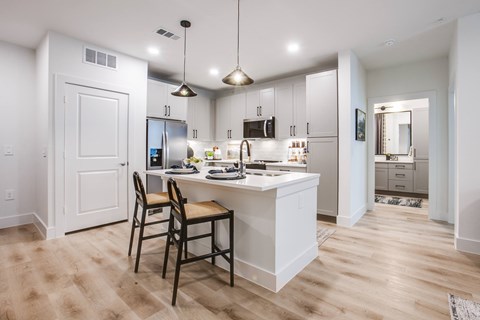 A kitchen with a white counter and a chair.