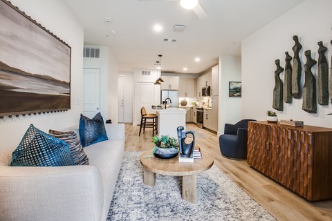 A living room with a white couch and a wooden coffee table.