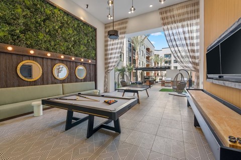 A room with a green wall and a pool table.
