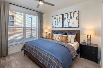 A bedroom with a bed, nightstand, and two wall art pieces.