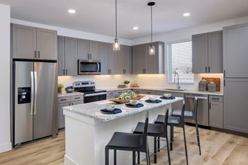 A modern kitchen with a central island and stainless steel appliances.