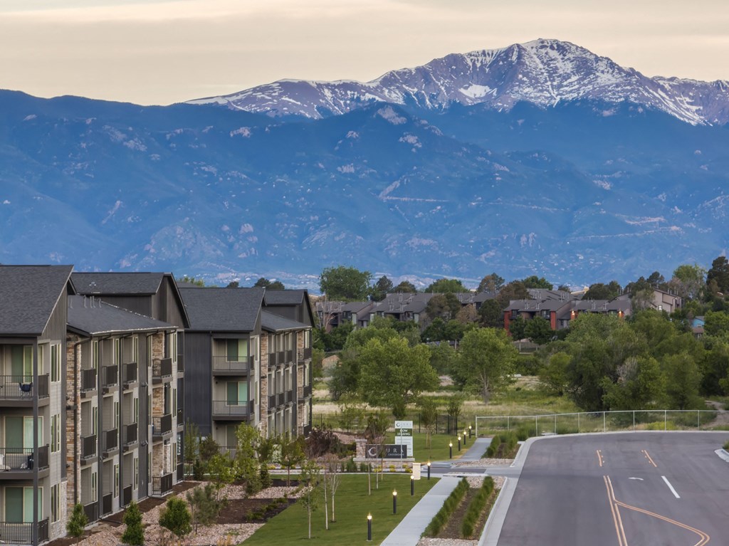 an aerial view of apartment buildings with mountains in the background