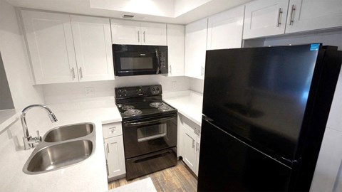 a kitchen with black appliances and white cabinets