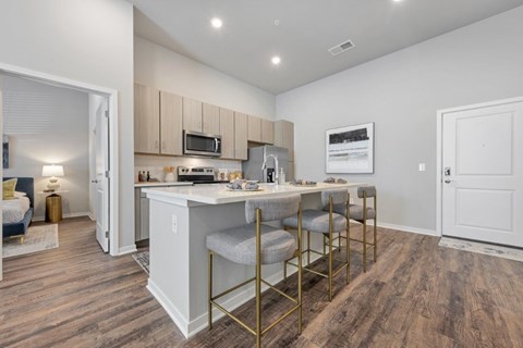 A kitchen area with a white counter and a microwave on top of it.