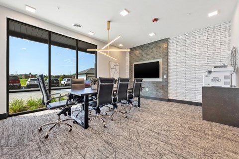 A conference room with a stone wall and a television.