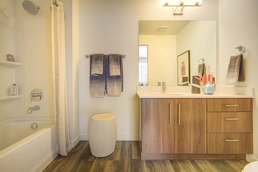 a bathroom with wooden cabinets and a white bathtub