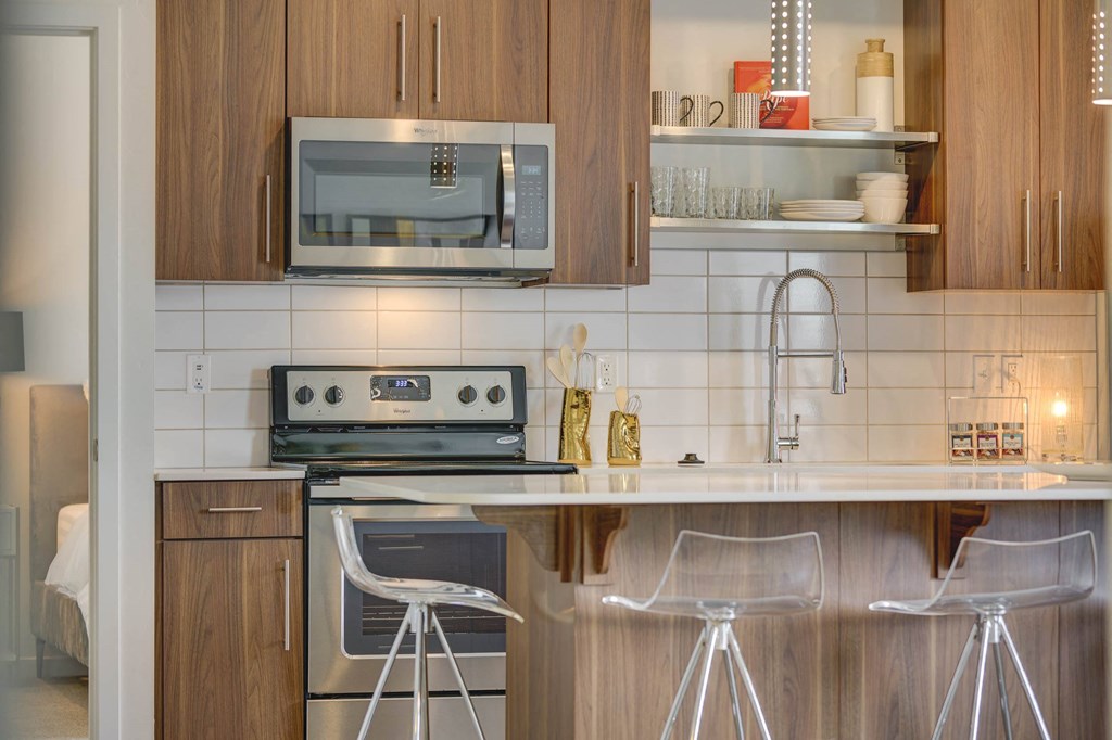 a kitchen with white tile and wooden cabinets