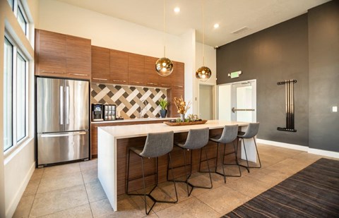 a kitchen with a bar and a stainless steel refrigerator