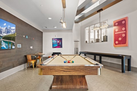 A pool table is in the middle of a room with a billiard table light.