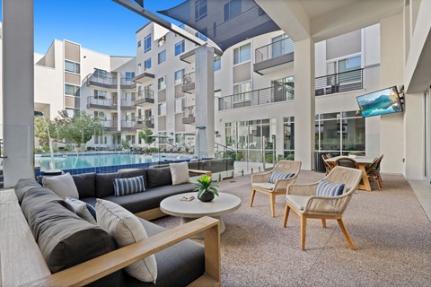 A modern outdoor living space with a pool and lounge chairs.