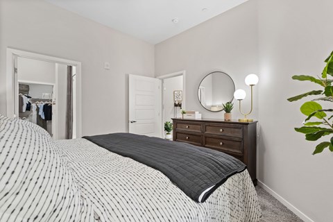 A bedroom with a large bed and a mirror on the wall.