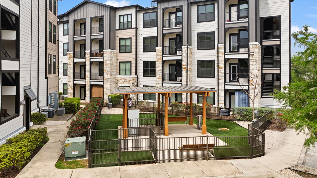 A modern apartment complex with a courtyard and a gazebo.