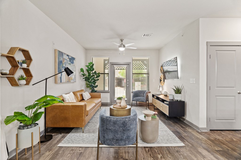 A living room with a brown couch, a grey armchair, and a wooden coffee table.