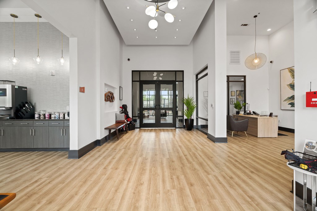 A modern office lobby with a wooden floor and white walls.
