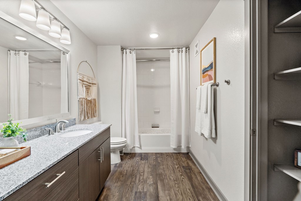 A bathroom with a white toilet, a white tub, and a white sink.