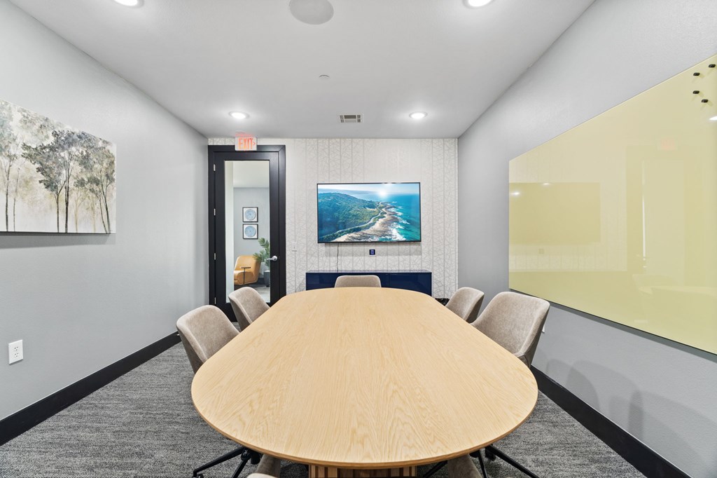 A conference room with a large table and chairs.