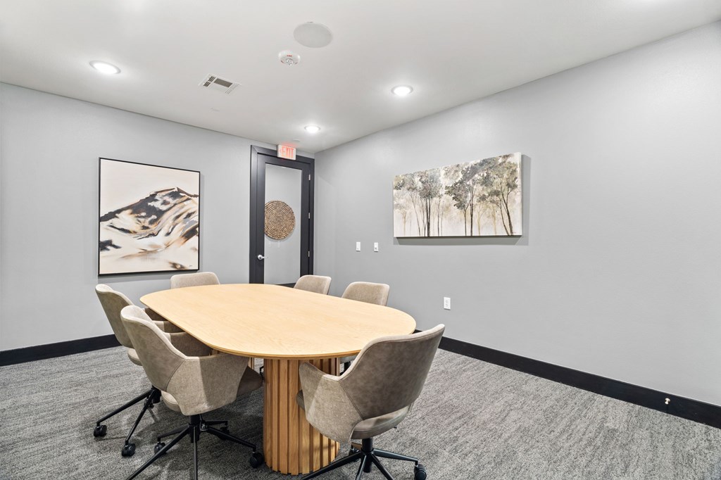 A conference room with a round table and chairs.