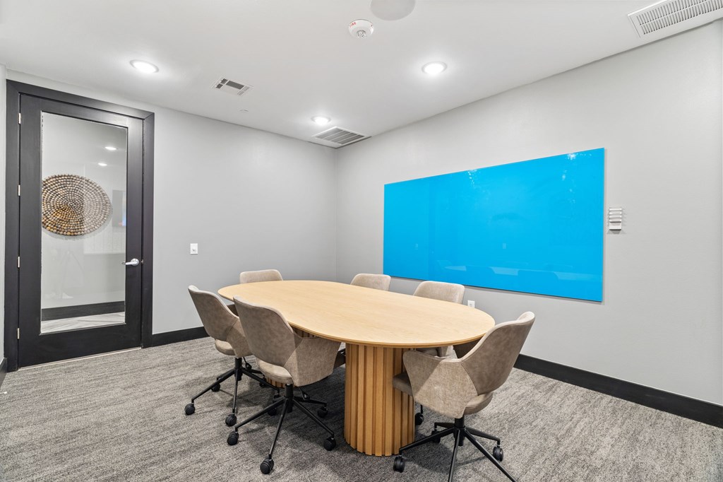 A conference room with a large table and chairs.