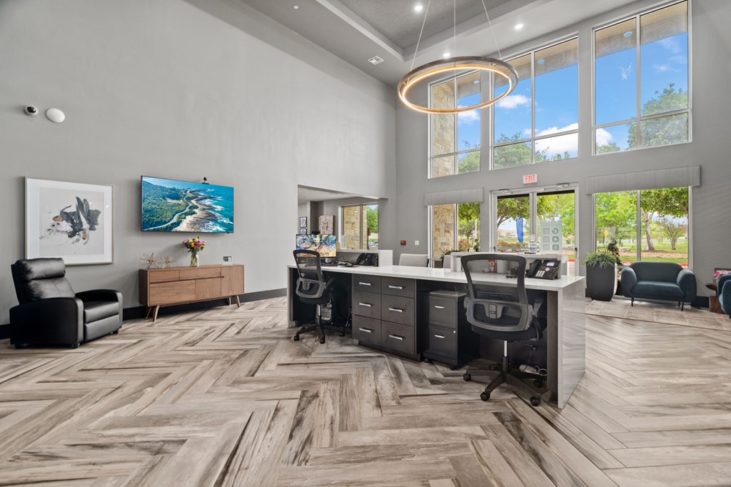 A modern office space with wood flooring and a large window.