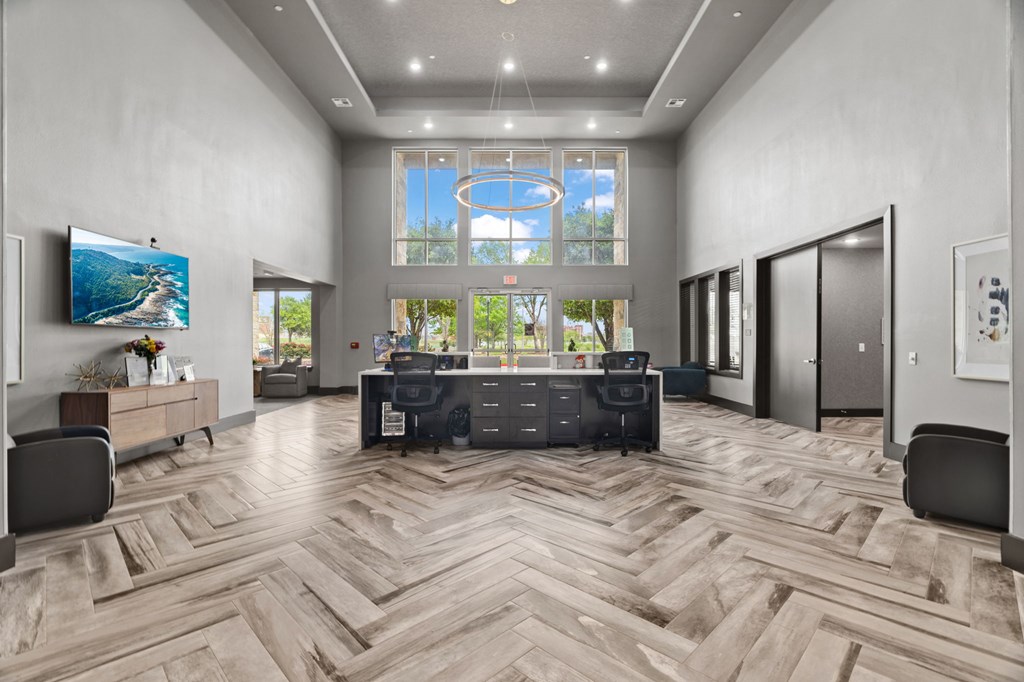 A modern office with a large desk and a flat screen TV.