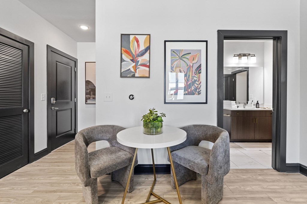 A modern dining room with a round table and grey chairs.