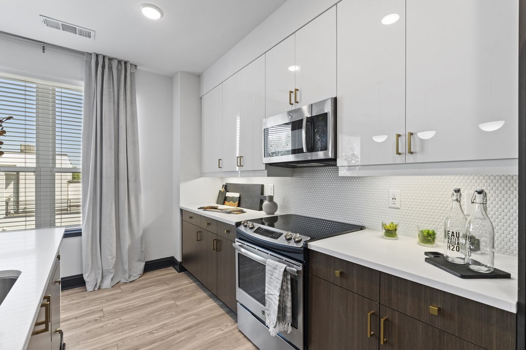 A modern kitchen with a stainless steel oven and white countertops.