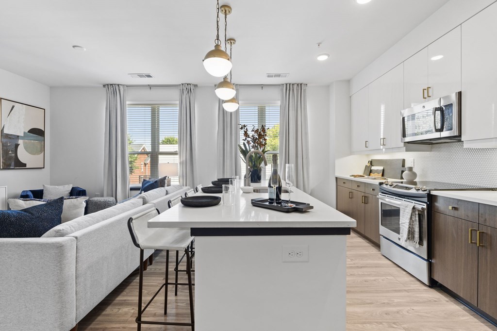 A modern kitchen with a white island and a dining area with a sofa.