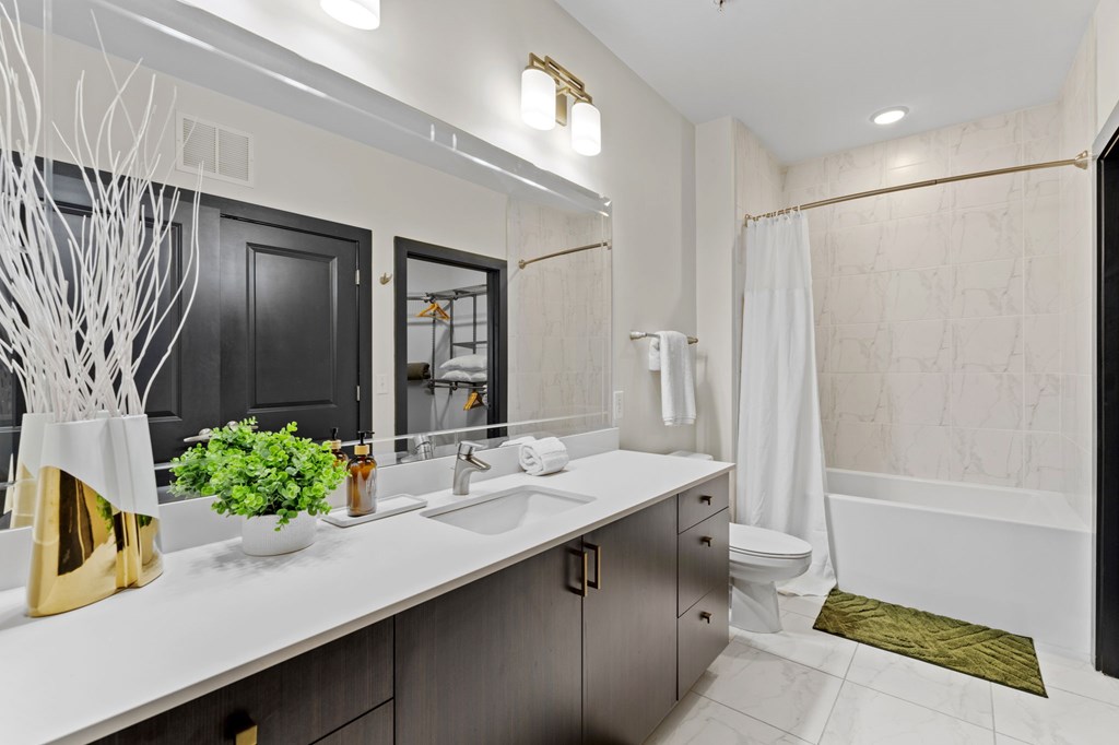 A bathroom with a white counter top and a black door.
