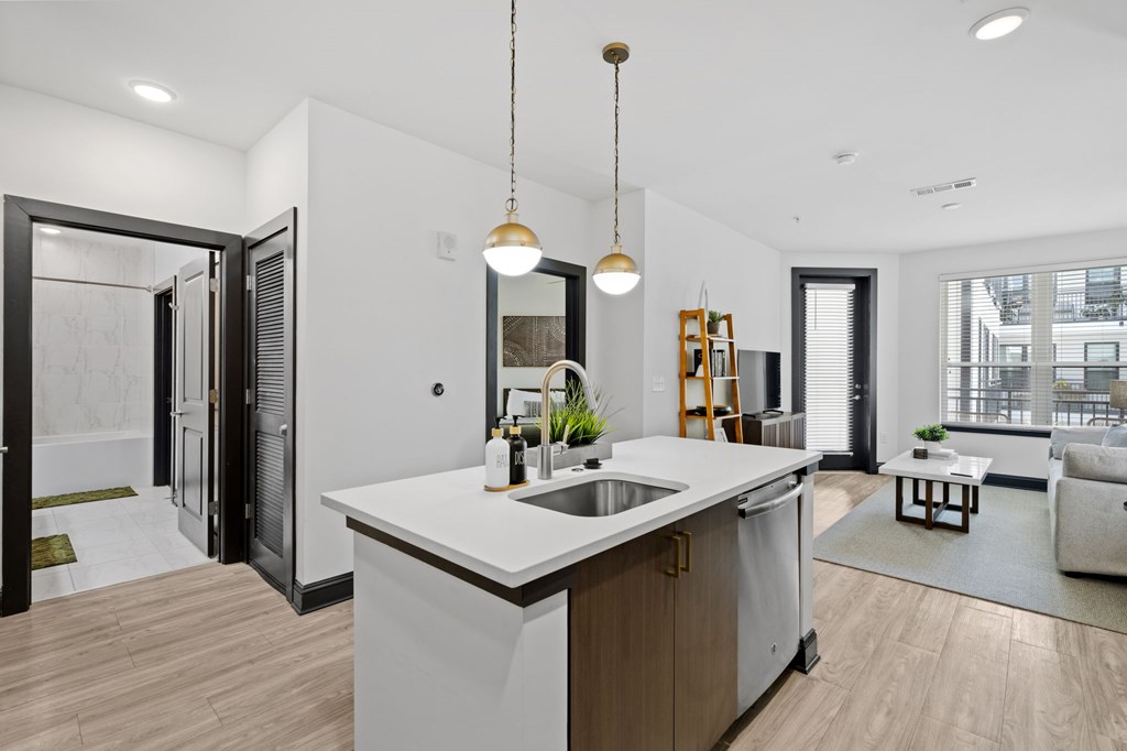 A modern kitchen with a white countertop and wooden cabinets.