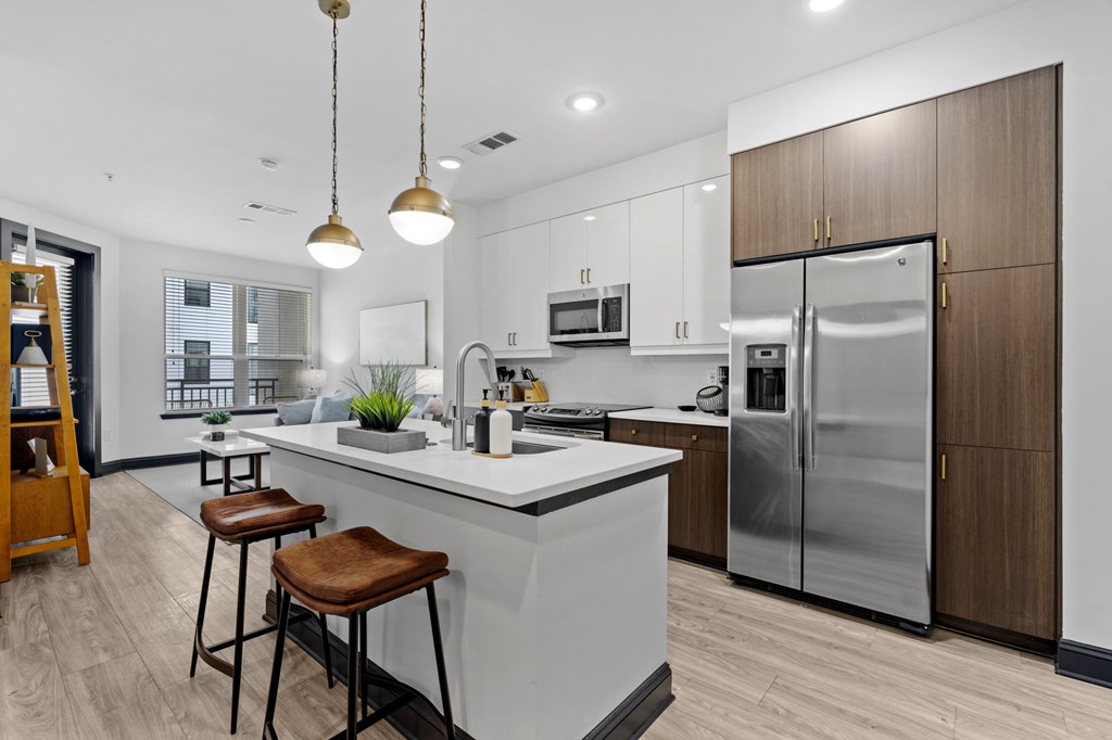 A modern kitchen with a white countertop and stainless steel appliances.