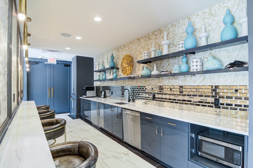 A kitchen with a marble countertop and blue cabinets.